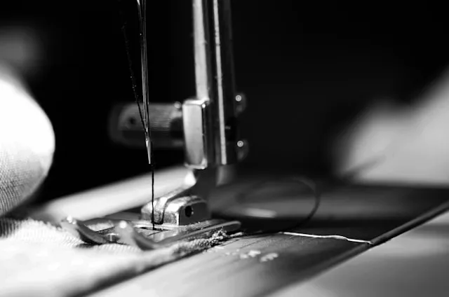 black and white image of a sewing machine needle for how to sew on a patch with a sewing machine