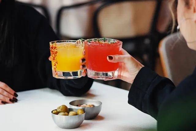 two people making a toast for diy cocktail table