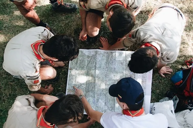a group of people looking at a map for how to attach boy scout patches