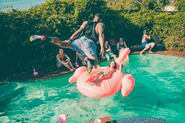 someone jumping into a pool at a party for pool party essentials