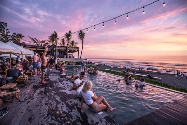 people relaxing beside a pool at sunset for pool party essentials
