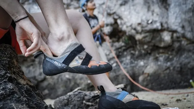 a person putting on climbing shoes for do you wear socks with climbing shoes