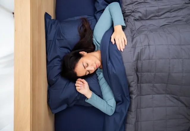 top-down view of a person sleeping in bed for comforter vs blanket
