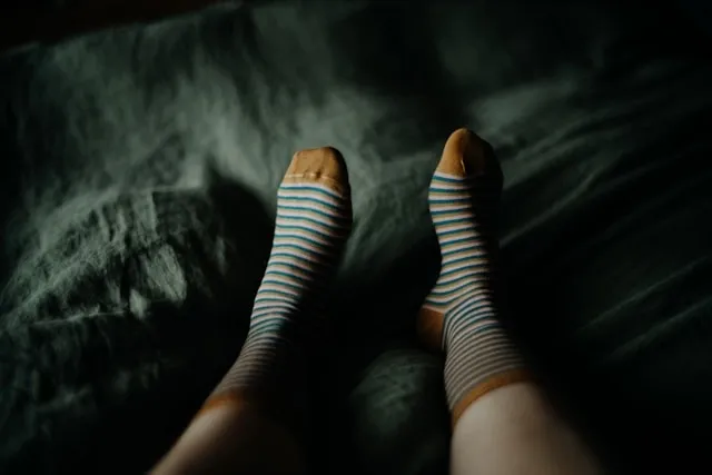 a pair of feet with socks on in bed for does sleeping with socks affect the brain