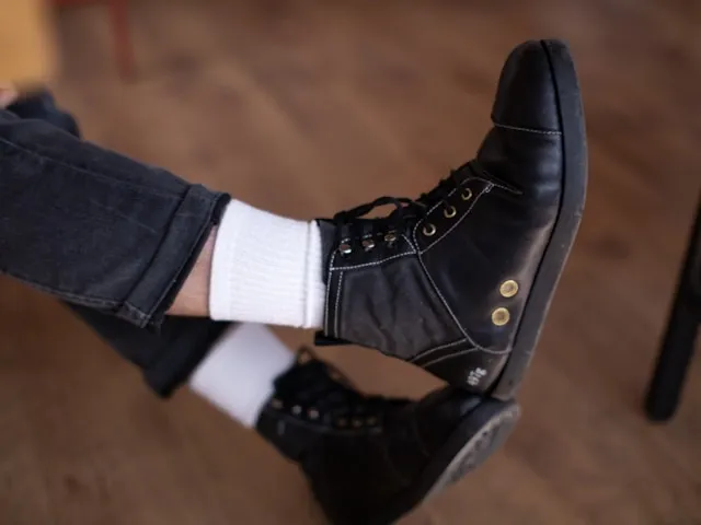 a person wearing white socks with black shoes for how to clean white socks