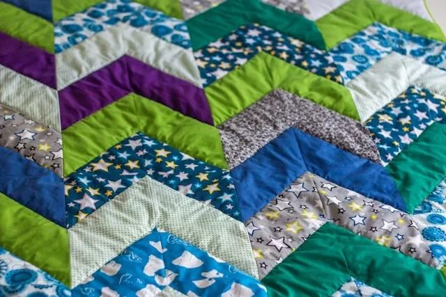 a close-up of a quilt for quilt vs blanket