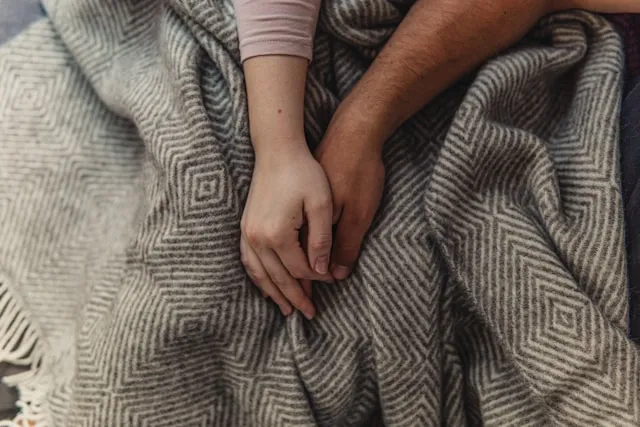 holding hands on a knitted blanket for how to wash wool blanket