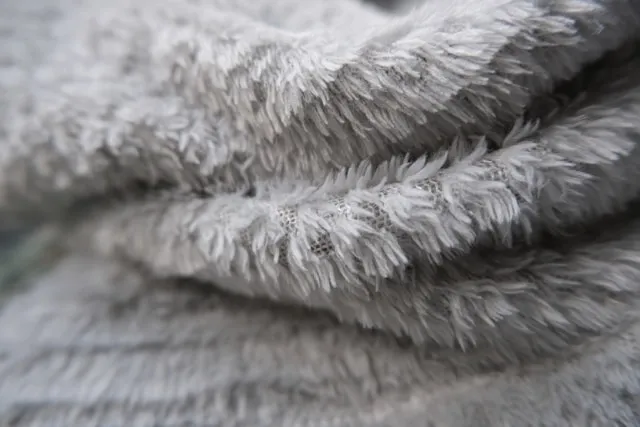 a close-up of a gray blanket for sherpa vs fleece blanket