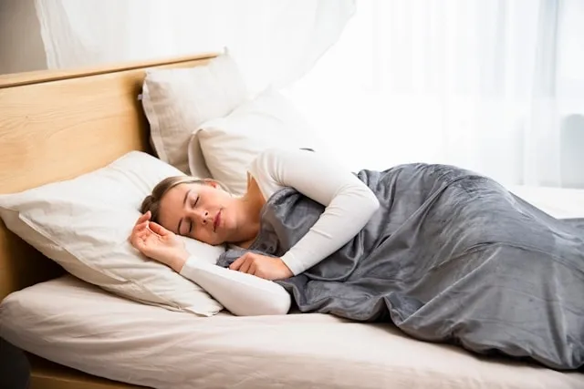 a person sleeping under a blanket for queen size blanket dimensions