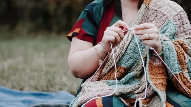a person knitting a blanket for how many yards of yarn for a blanket