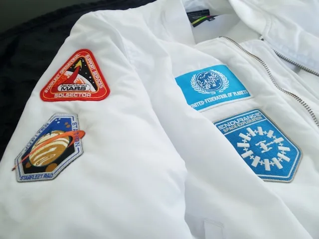 patches on a white jacket for how to iron on patches with parchment paper