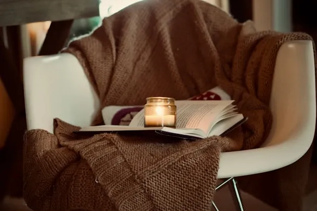 a blanket draped over a chair with a book for weighted blanket benefits