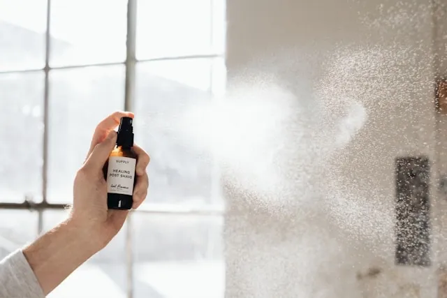 a person spraying room freshener for how to use room freshener