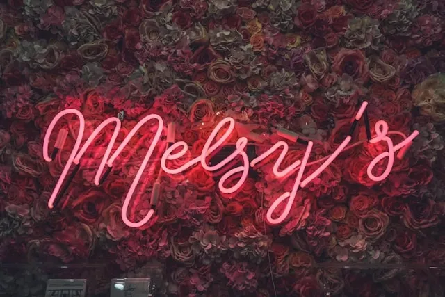 a red neon sign on a floral backdrop for how to hang a neon sign on a wall without nails