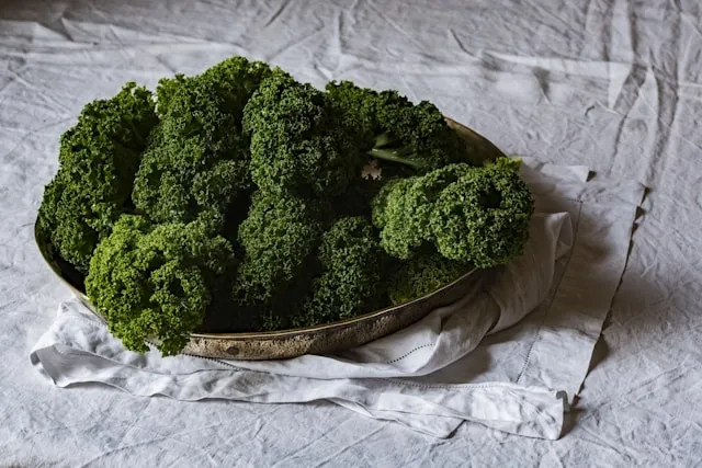green vegetables in a bowl on white linens for how to steam tablecloths