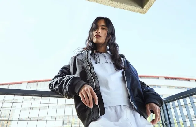 a person wearing a bomber jacket and tracksuit for how to style a military jacket
