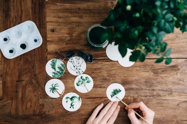 a person painting on coaster bases for diy coaster ideas