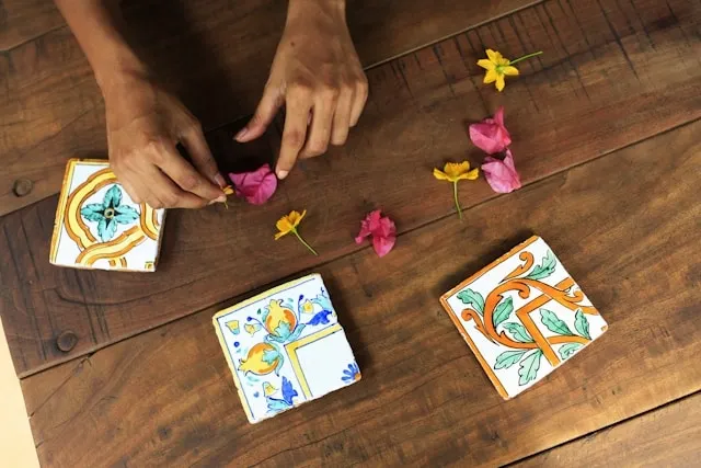 a person with hand-painted tile coasters for diy coaster ideas