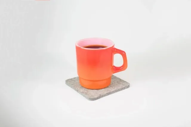 an orange cup on a gray felt coaster for how to clean felt coasters