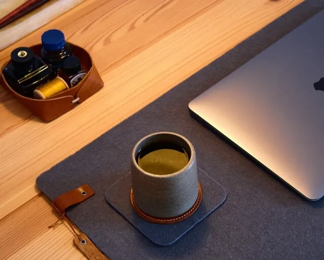 a workspace with a laptop and coffee for how to clean felt coasters