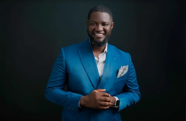 a person smiling in a blue suit for can you wear a lapel pin and pocket square