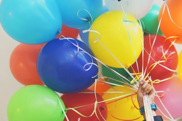 a person holding colorful balloons by how to use balloon tying tool a person holding colorful balloons by how to use balloon tying tool