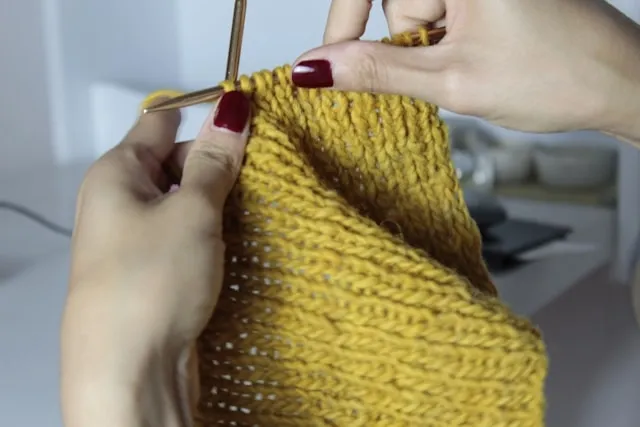 a person knitting with yellow yarn for knit table runner a person knitting with yellow yarn for knit table runner