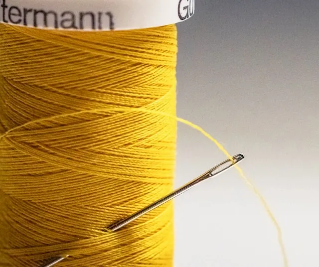 a needle and some yellow thread for blanket stitch by hand a needle and some yellow thread for blanket stitch by hand