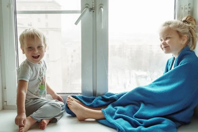 two children sitting beside a window for how to wash a fleece blanket two children sitting beside a window for how to wash a fleece blanket