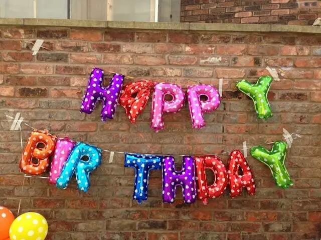 colored balloons hanging on a brick wall for how to inflate foil balloons