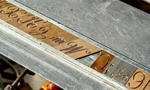 Close-up of detailed laser-engraved cursive lettering showing the precision and contrast achievable when engraving leather patches