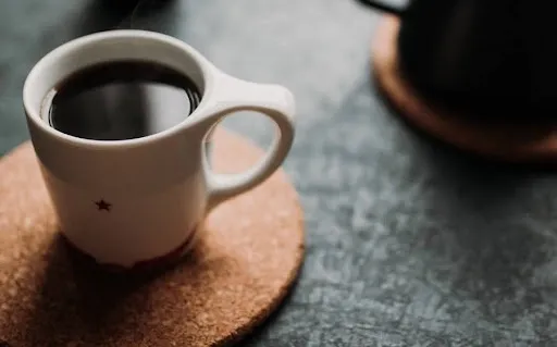 Coffee mug resting on a finished printed cork coaster, the kind of custom cork coaster you can make and sell Coffee mug resting on a finished printed cork coaster, the kind of custom cork coaster you can make and sell