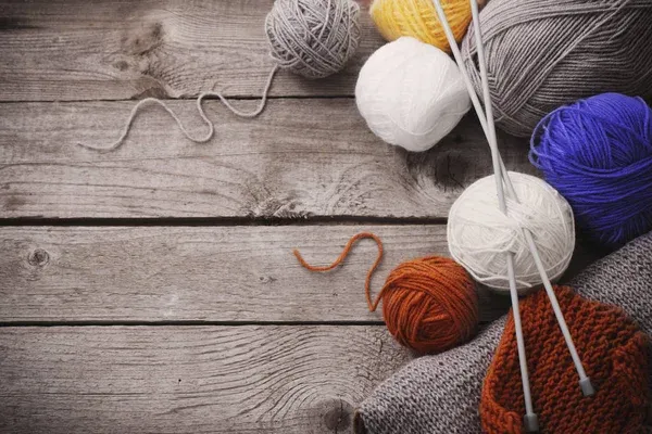Knitting material on a wooden surface Knitting material on a wooden surface