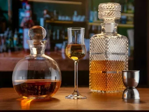 Personalized whiskey gift set with crystal decanters and an engraved tasting glass on a bar Personalized whiskey gift set with crystal decanters and an engraved tasting glass on a bar