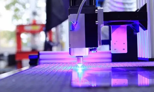 Laser engraving machine in action with a bright blue laser beam, suitable for engraving custom leather patches