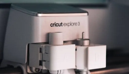 Cricut cutting machine cutting heat transfer vinyl for a cork coaster design before weeding Cricut cutting machine cutting heat transfer vinyl for a cork coaster design before weeding