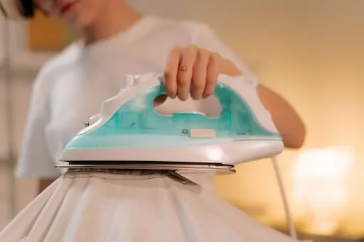 Household iron pressing firm downward pressure onto a chenille patch covered with a white pressing cloth.jpg Household iron pressing firm downward pressure onto a chenille patch covered with a white pressing cloth.jpg