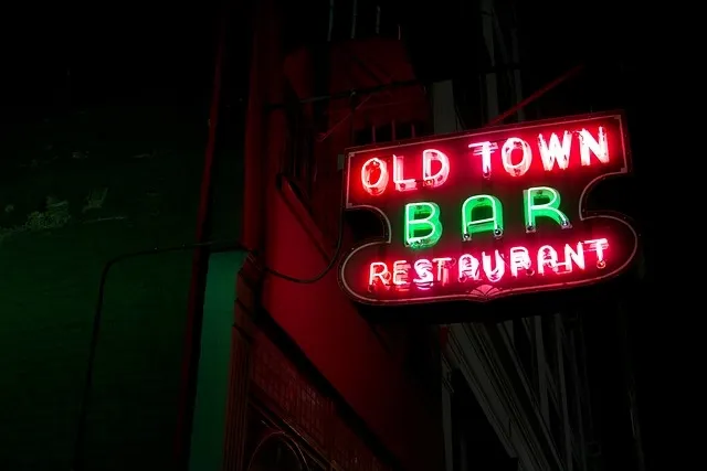 A red and green Old Town Bar Restaurant neon sign glowing outside at night