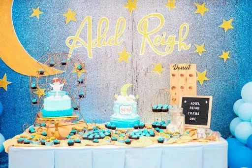 Plastic tablecloth party backdrop hung smoothly on a wall behind a birthday dessert table with cakes and treats.jpg Plastic tablecloth party backdrop hung smoothly on a wall behind a birthday dessert table with cakes and treats.jpg