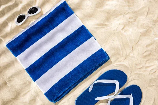 Folded towel and flip-flop on a beach Folded towel and flip-flop on a beach