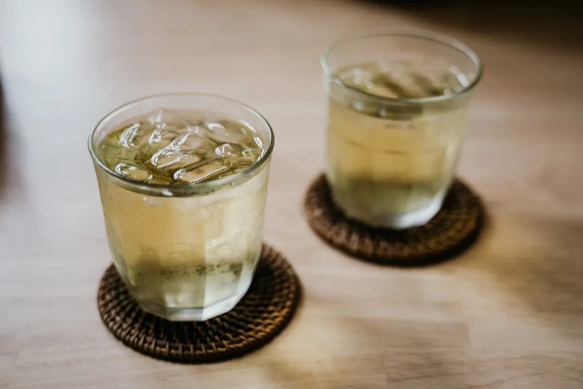 Two iced tea glasses sweating onto absorbent coasters, showing why the best coasters for sweaty drinks need porous materials Two iced tea glasses sweating onto absorbent coasters, showing why the best coasters for sweaty drinks need porous materials