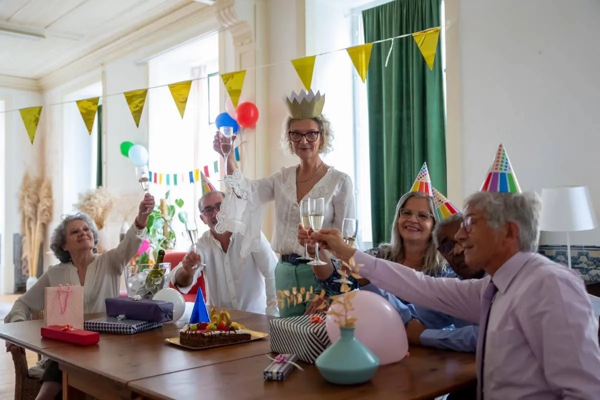 Friends in party hats celebrating a milestone birthday around a decorated table, ideas for planning a 50th birthday party Friends in party hats celebrating a milestone birthday around a decorated table, ideas for planning a 50th birthday party