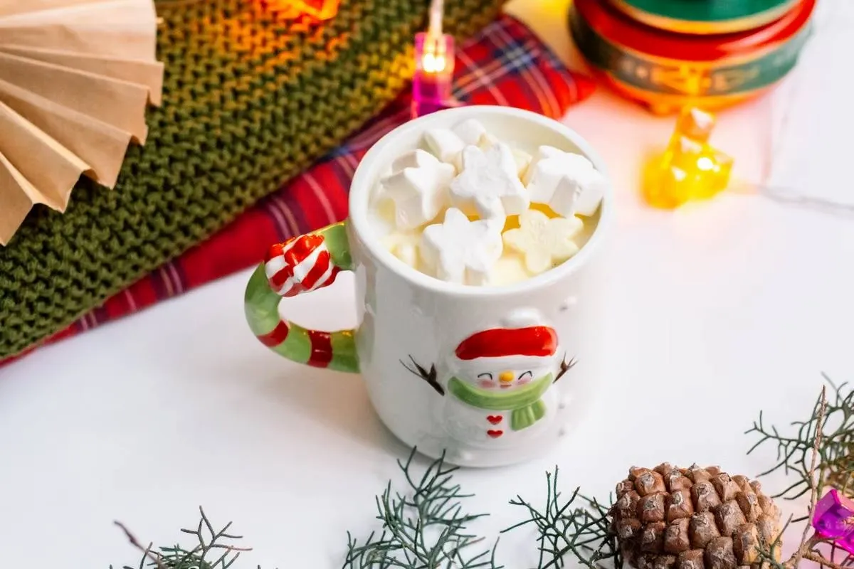Hot cocoa mug topped with marshmallows on a Christmas coaster, a test of heat resistance for everyday holiday use Hot cocoa mug topped with marshmallows on a Christmas coaster, a test of heat resistance for everyday holiday use