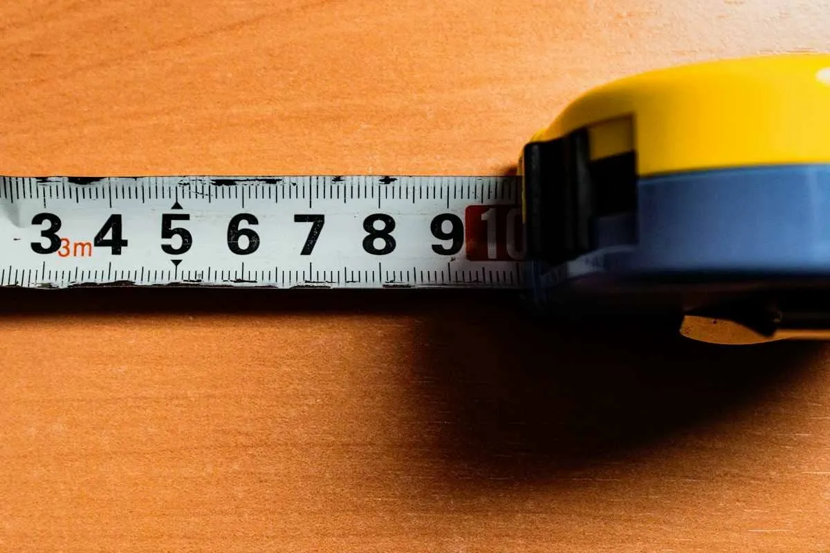 Tape measure extended across a table surface to measure width before choosing a tablecloth size.jpg Tape measure extended across a table surface to measure width before choosing a tablecloth size.jpg