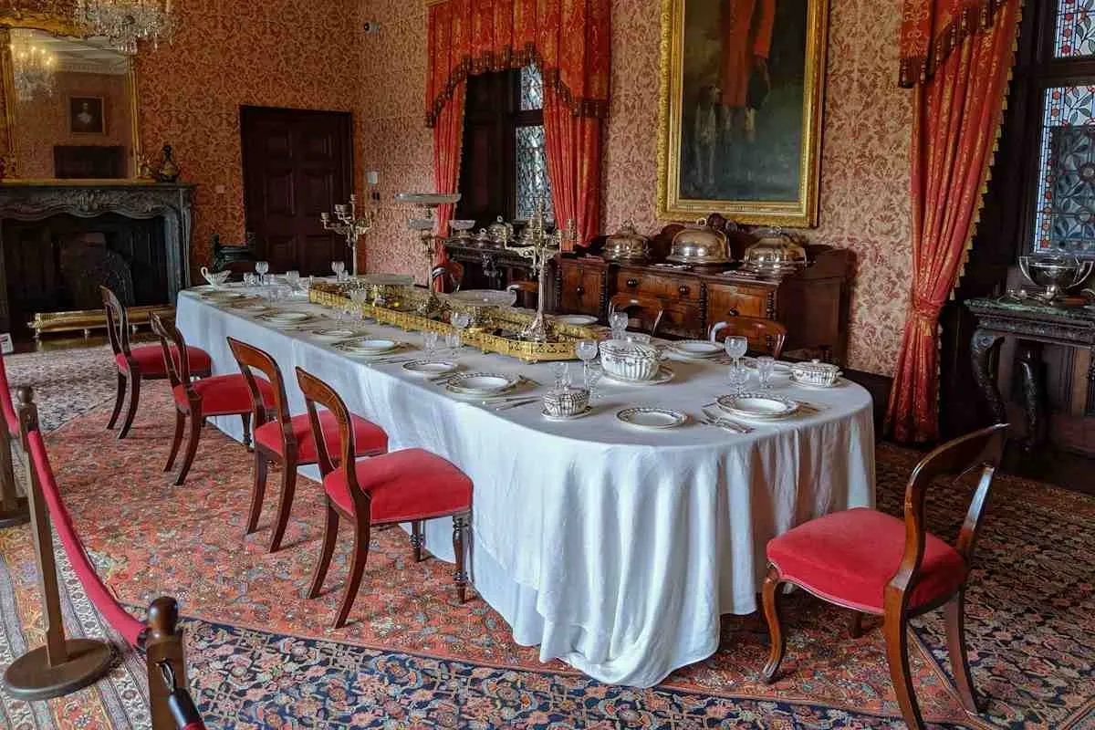 Long formal dining table fully set with linens, plates and glassware for a sit-down meal.jpg Long formal dining table fully set with linens, plates and glassware for a sit-down meal.jpg