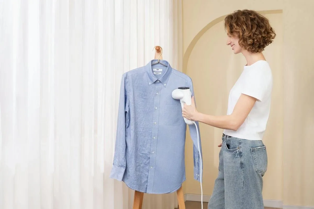 Handheld steamer held a few inches from hanging fabric to relax wrinkles without pressing, the same method used on burlap table runners.jpg