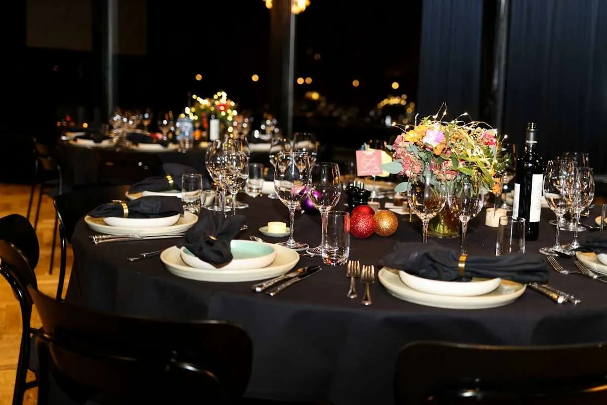 Event tables dressed in black tablecloths with place settings and floral centerpieces.jpg Event tables dressed in black tablecloths with place settings and floral centerpieces.jpg