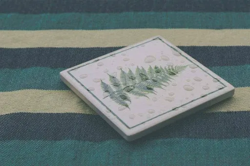 Green and white ceramic tile coaster with a hand-painted fern botanical motif, showing a stylish DIY painted coaster idea for a coordinated set.jpg Green and white ceramic tile coaster with a hand-painted fern botanical motif, showing a stylish DIY painted coaster idea for a coordinated set.jpg