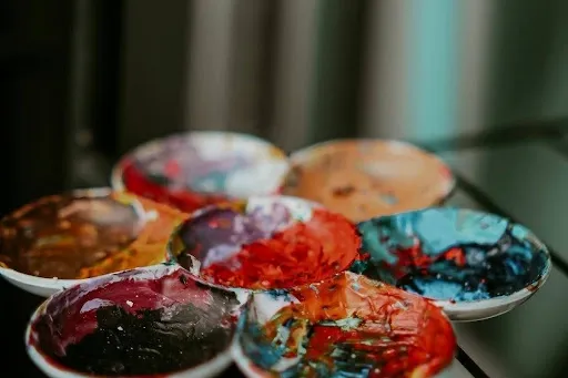 Ceramic bowls filled with mixed acrylic paint on a glass table showing the paint mixing stage for DIY painted coasters and acrylic pour projects.jpg Ceramic bowls filled with mixed acrylic paint on a glass table showing the paint mixing stage for DIY painted coasters and acrylic pour projects.jpg