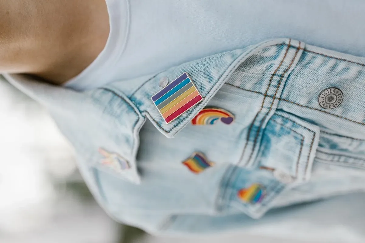 Front view of a denim jacket with a balanced arrangement of colorful patches and pins for placement inspiration